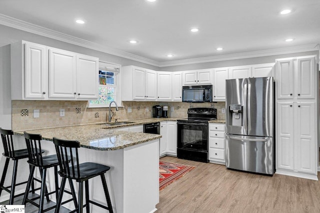 500 E Mountain Creek Rd, Taylors, SC 29687 - kitchen with black appliances, a sink, a peninsula, light wood-type flooring, and light stone countertops