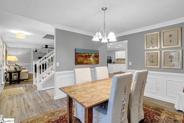 500 E Mountain Creek Rd, Taylors, SC 29687 - dining space featuring light wood finished floors, ornamental molding, a chandelier, stairs, and a decorative wall