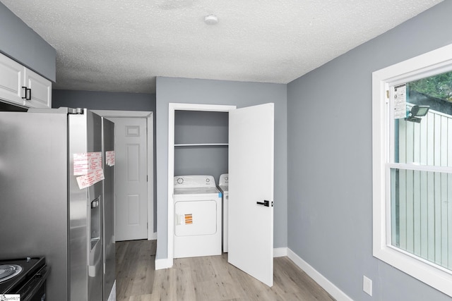 127 Chelsea St, Moore, SC 29369 - laundry room with light wood finished floors, a textured ceiling, baseboards, and washing machine and clothes dryer