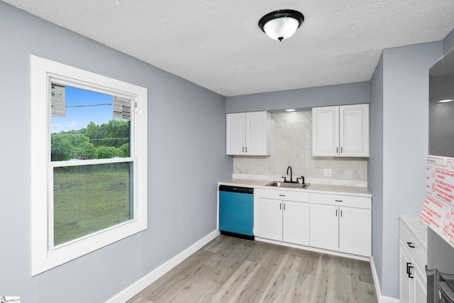 127 Chelsea St, Moore, SC 29369 - kitchen with dishwashing machine, a sink, decorative backsplash, light countertops, and light wood-type flooring