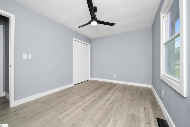 127 Chelsea St, Moore, SC 29369 - unfurnished bedroom featuring light wood-style flooring, multiple windows, a textured ceiling, and baseboards