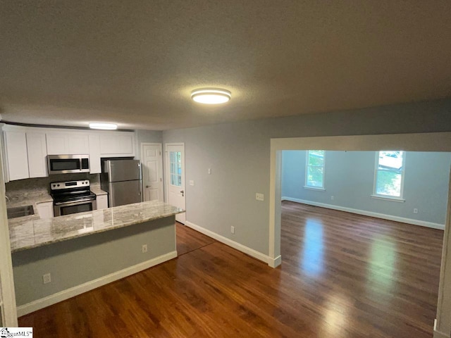 1002 Still Holllow Ln, Taylors, SC 29687 - kitchen with stainless steel appliances, white cabinetry, dark wood-style floors, and a textured ceiling