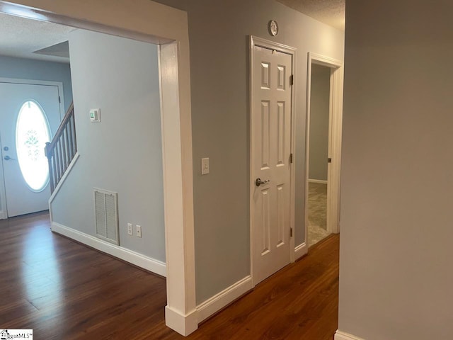 1002 Still Holllow Ln, Taylors, SC 29687 - hall featuring dark wood-style floors, baseboards, stairway, and a textured ceiling