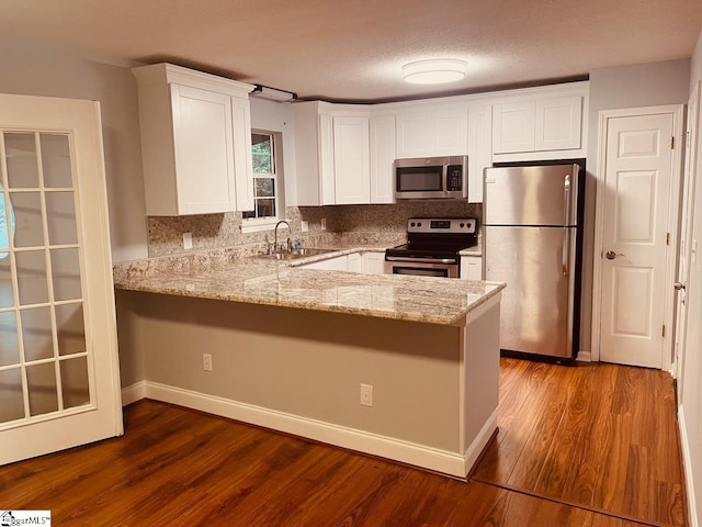 1002 Still Holllow Ln, Taylors, SC 29687 - kitchen with stainless steel appliances, a peninsula, white cabinetry, a sink, and a textured ceiling
