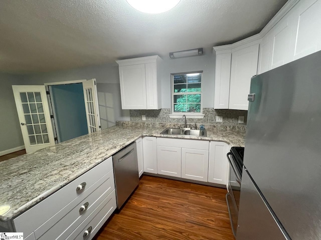 1002 Still Holllow Ln, Taylors, SC 29687 - kitchen featuring appliances with stainless steel finishes, a sink, white cabinets, a peninsula, and backsplash