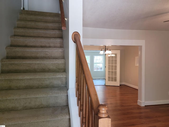 1002 Still Holllow Ln, Taylors, SC 29687 - staircase featuring wood finished floors, baseboards, a chandelier, and a textured ceiling