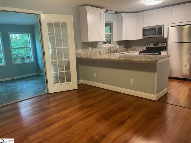 1002 Still Holllow Ln, Taylors, SC 29687 - kitchen with stainless steel appliances, white cabinetry, stone counters, and decorative backsplash