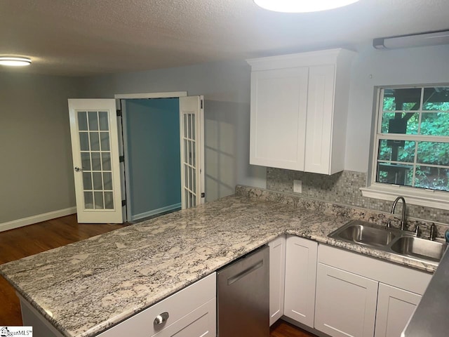 1002 Still Holllow Ln, Taylors, SC 29687 - kitchen with a sink, stainless steel dishwasher, a peninsula, dark wood-style floors, and white cabinets