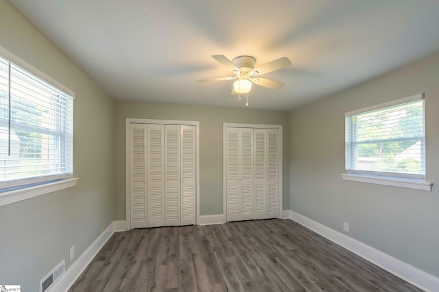 418 N Alabama Ave, Chesnee, SC 29323 - unfurnished bedroom with two closets, wood finished floors, baseboards, and ceiling fan
