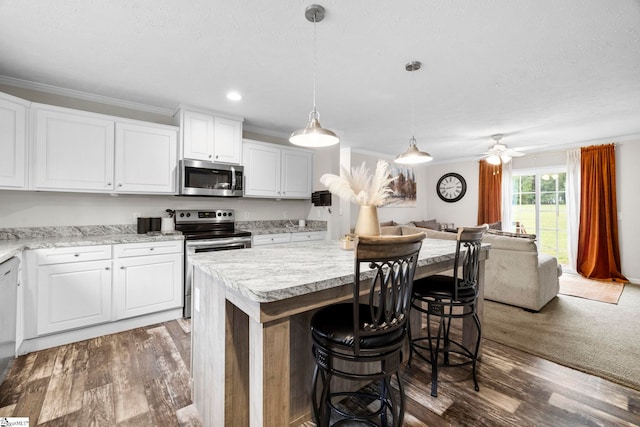 105 Penson Rd, Honea Path, SC 29654 - kitchen with stainless steel appliances, crown molding, open floor plan, light countertops, and white cabinets