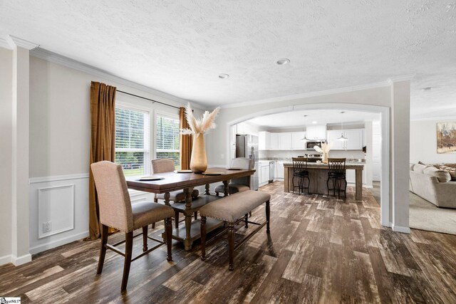 105 Penson Rd, Honea Path, SC 29654 - dining area with arched walkways, dark wood-style flooring, ornamental molding, a textured ceiling, and wainscoting