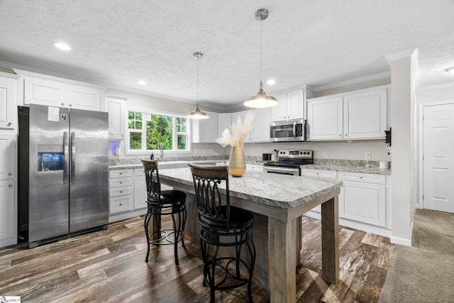 105 Penson Rd, Honea Path, SC 29654 - kitchen with stainless steel appliances, crown molding, white cabinets, a kitchen island, and a breakfast bar area