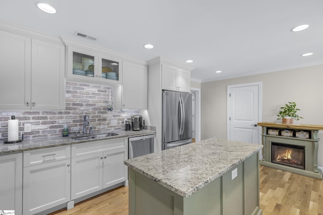 121 Lowe Rd, Piedmont, SC 29673 - kitchen featuring stainless steel appliances, a sink, white cabinets, crown molding, and decorative backsplash