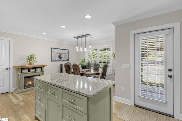 121 Lowe Rd, Piedmont, SC 29673 - kitchen featuring a center island, light wood-type flooring, crown molding, hanging light fixtures, and light stone countertops