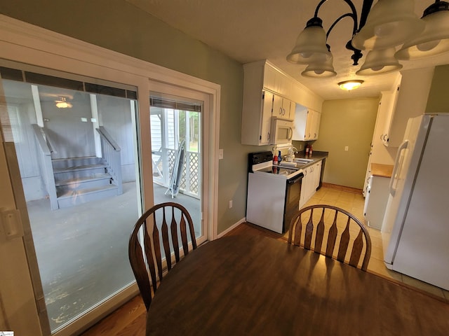 242 Lewis Rd, Williamston, SC 29697 - kitchen with white appliances, a sink, baseboards, a chandelier, and white cabinetry