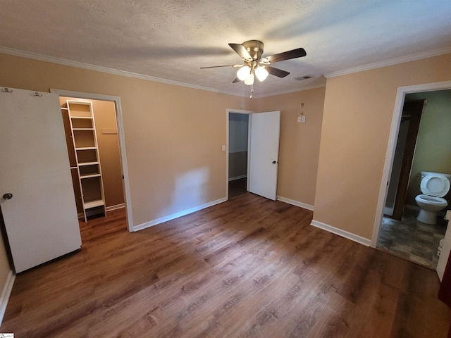 242 Lewis Rd, Williamston, SC 29697 - unfurnished bedroom featuring baseboards, wood finished floors, ornamental molding, a spacious closet, and a closet
