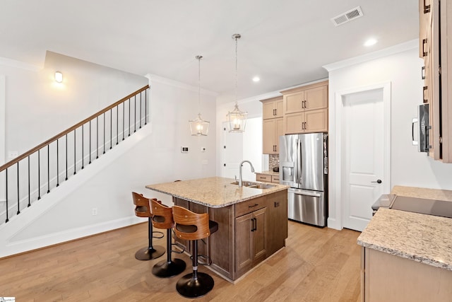 1 Winding Rock Rd, Simpsonville, SC 29680 - kitchen featuring appliances with stainless steel finishes, light wood finished floors, a sink, ornamental molding, and a center island with sink