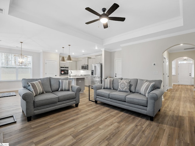 4427 Storehouse Run, Boiling Springs, SC 29316 - living room with a raised ceiling, arched walkways, light wood-style flooring, a ceiling fan, and baseboards