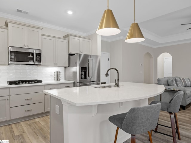 4427 Storehouse Run, Boiling Springs, SC 29316 - kitchen featuring appliances with stainless steel finishes, a sink, arched walkways, light wood finished floors, and a breakfast bar area