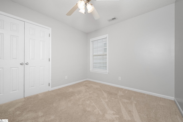 208 Cosmic Ct, Greer, SC 29651 - unfurnished bedroom featuring light colored carpet, baseboards, a closet, a ceiling fan, and a textured ceiling