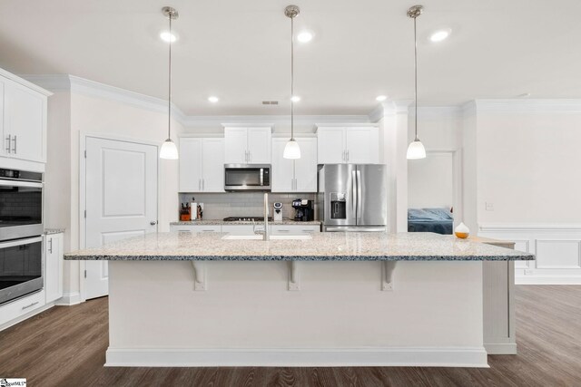 305 Kellen Ct, Duncan, SC 29334 - kitchen featuring appliances with stainless steel finishes, a breakfast bar, a kitchen island with sink, dark wood-type flooring, and crown molding