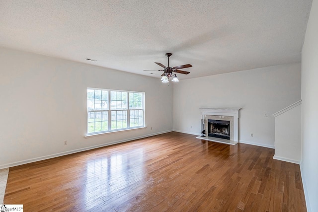 19 Hartwell Dr, Simpsonville, SC 29681 - unfurnished living room with wood finished floors, a textured ceiling, a ceiling fan, a premium fireplace, and baseboards