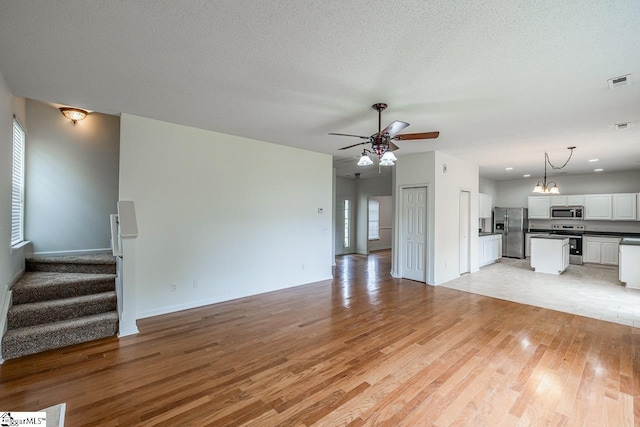 19 Hartwell Dr, Simpsonville, SC 29681 - unfurnished living room featuring ceiling fan, light wood-style floors, stairway, and baseboards