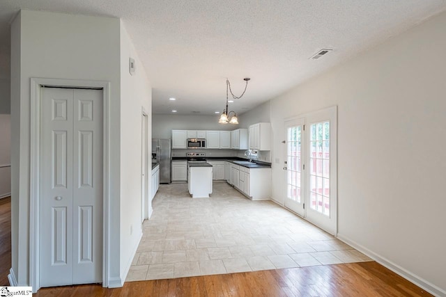19 Hartwell Dr, Simpsonville, SC 29681 - kitchen with stainless steel appliances, dark countertops, white cabinets, a chandelier, and baseboards
