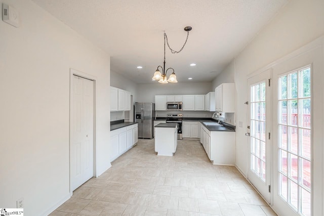 19 Hartwell Dr, Simpsonville, SC 29681 - kitchen with stainless steel appliances, dark countertops, a chandelier, white cabinetry, and hanging light fixtures