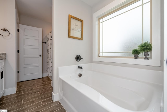 881 Cothran Rd, Inman, SC 29349 - bathroom with a garden tub, vanity, wood finished floors, and baseboards