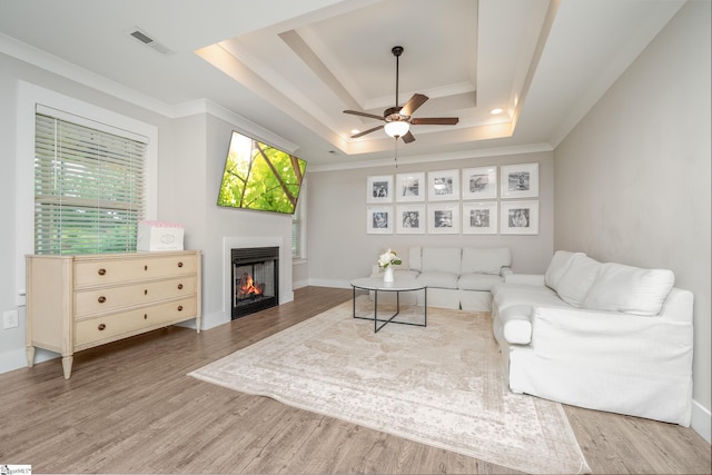 881 Cothran Rd, Inman, SC 29349 - living area featuring a raised ceiling, ornamental molding, wood finished floors, a ceiling fan, and a warm lit fireplace