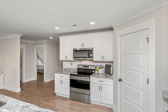 881 Cothran Rd, Inman, SC 29349 - kitchen with appliances with stainless steel finishes, crown molding, baseboards, light wood finished floors, and light stone counters