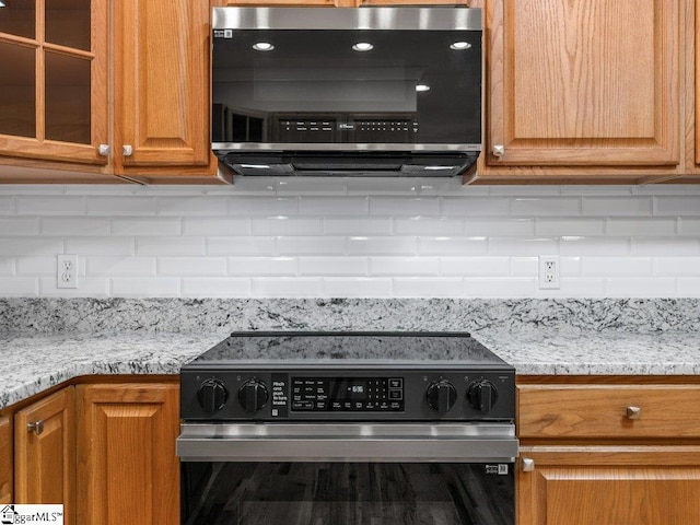 251 Saddlebrook Dr, Moore, SC 29369 - kitchen featuring electric range oven, decorative backsplash, glass insert cabinets, and light stone counters