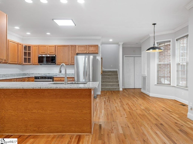 251 Saddlebrook Dr, Moore, SC 29369 - kitchen with appliances with stainless steel finishes, brown cabinetry, a sink, crown molding, and light wood-style floors