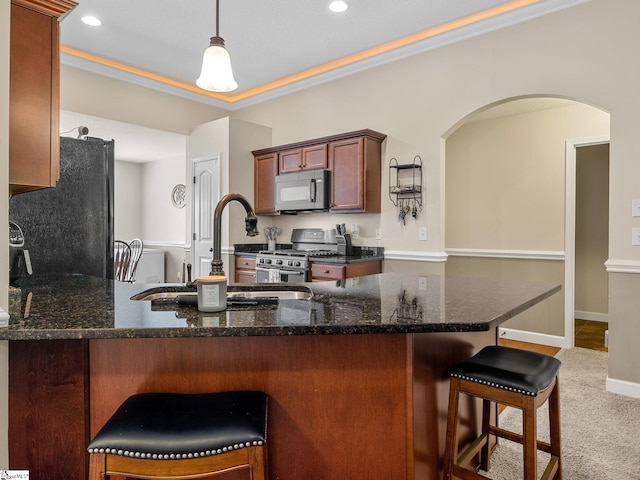 227 Heritage Creek Dr, Boiling Springs, SC 29316 - kitchen featuring stainless steel range with gas stovetop, arched walkways, freestanding refrigerator, a sink, and dark stone countertops