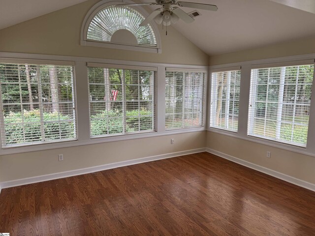 unfurnished sunroom featuring lofted ceiling, baseboards, and wood finished floors