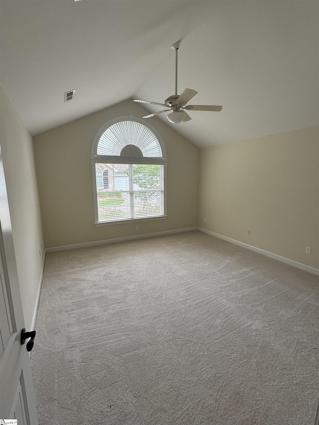 empty room with ceiling fan, carpet, lofted ceiling, and baseboards