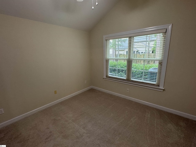 unfurnished room featuring carpet flooring, baseboards, lofted ceiling, and ceiling fan