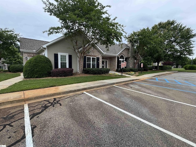 view of front of property with uncovered parking and brick siding