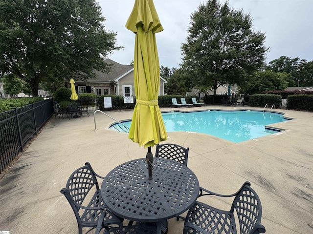 community pool featuring a patio area and outdoor dining area