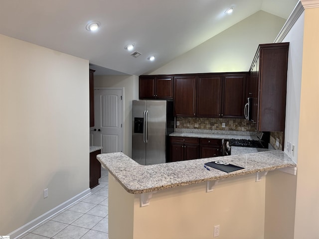 kitchen featuring appliances with stainless steel finishes, lofted ceiling, a peninsula, backsplash, and dark brown cabinets