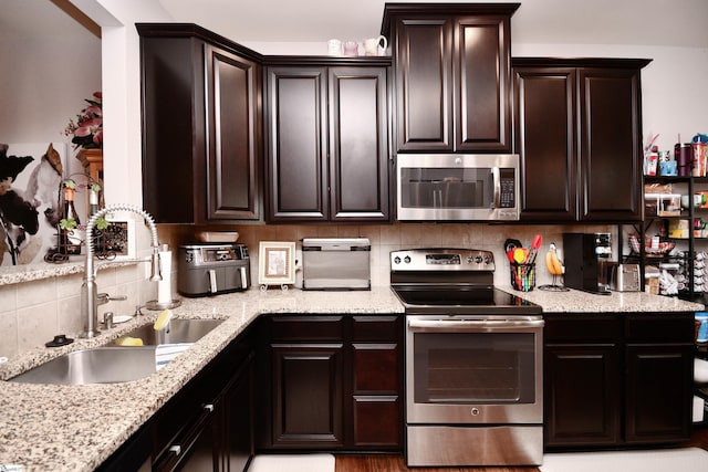 41 Irvington Dr, Greer, SC 29650 - kitchen featuring stainless steel appliances, a sink, tasteful backsplash, dark brown cabinets, and light stone counters