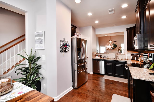 41 Irvington Dr, Greer, SC 29650 - kitchen featuring appliances with stainless steel finishes, a sink, light stone counters, dark wood-type flooring, and decorative backsplash