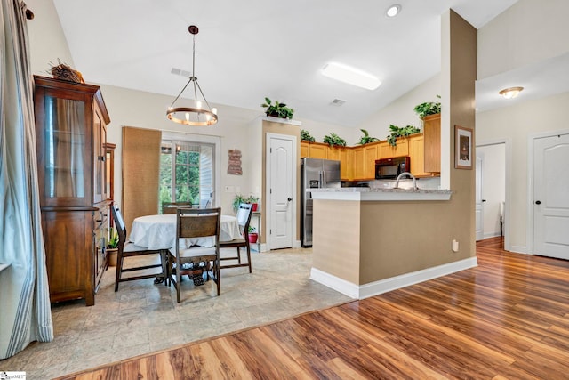 104 Penrith Ct, Simpsonville, SC 29681 - kitchen featuring black microwave, vaulted ceiling, stainless steel refrigerator with ice dispenser, light wood-type flooring, and a peninsula