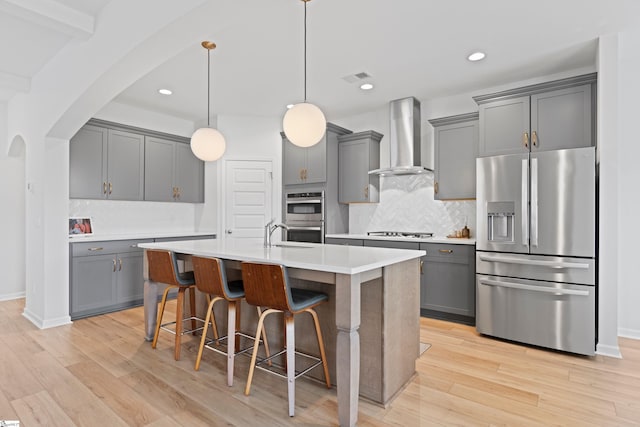 603 Betony Way, Greenville, SC 29607 - kitchen with stainless steel appliances, wall chimney range hood, gray cabinetry, arched walkways, and tasteful backsplash