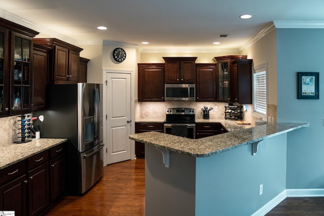 140 Belgian Blue Way, Fountain Inn, SC 29644 - kitchen with stainless steel appliances, dark brown cabinets, a kitchen bar, backsplash, and recessed lighting
