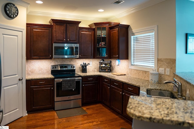 140 Belgian Blue Way, Fountain Inn, SC 29644 - kitchen with appliances with stainless steel finishes, a sink, dark wood-type flooring, dark brown cabinets, and ornamental molding