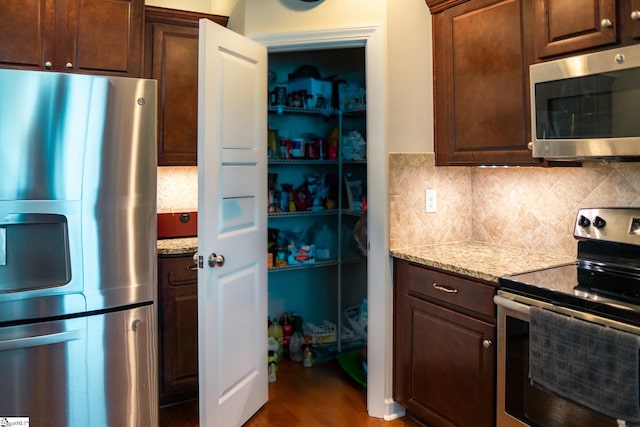 140 Belgian Blue Way, Fountain Inn, SC 29644 - kitchen with appliances with stainless steel finishes, backsplash, light stone counters, and dark brown cabinets