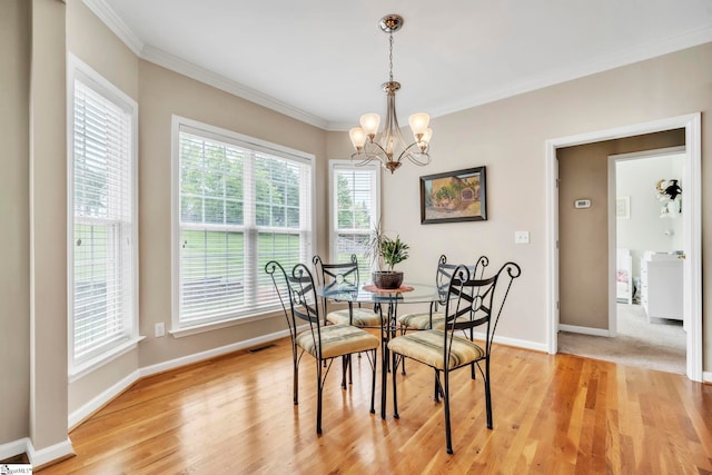 721 Dutchman Ct, Greer, SC 29651 - dining area featuring a chandelier, ornamental molding, healthy amount of natural light, baseboards, and light wood-style floors
