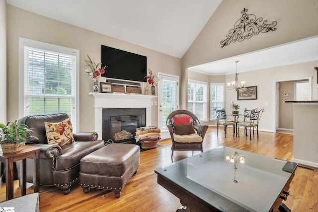 721 Dutchman Ct, Greer, SC 29651 - living area with a chandelier, a glass covered fireplace, light wood-style flooring, and high vaulted ceiling